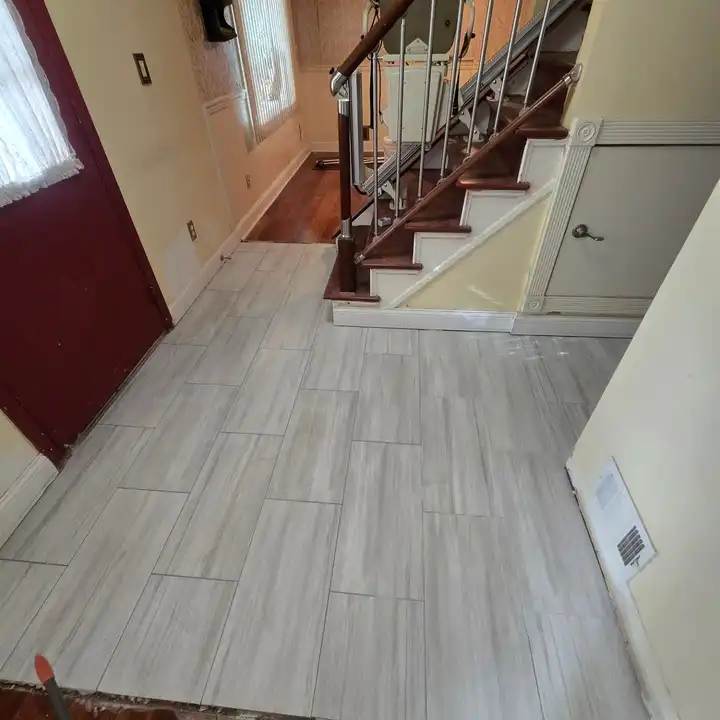 Entry hall in wood-look plank tile at the foot of the stairs