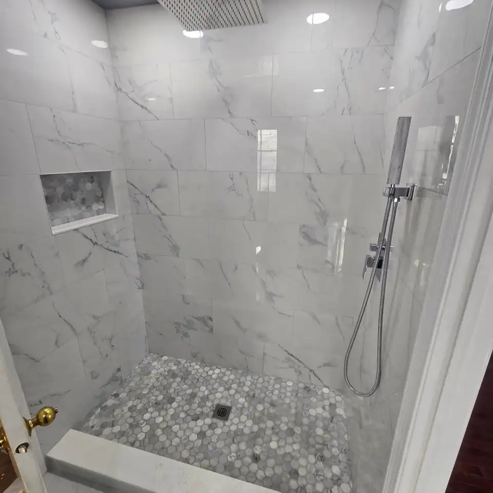 Walk-in shower in large-format marble-look porcelain with a hexagon mosaic floor