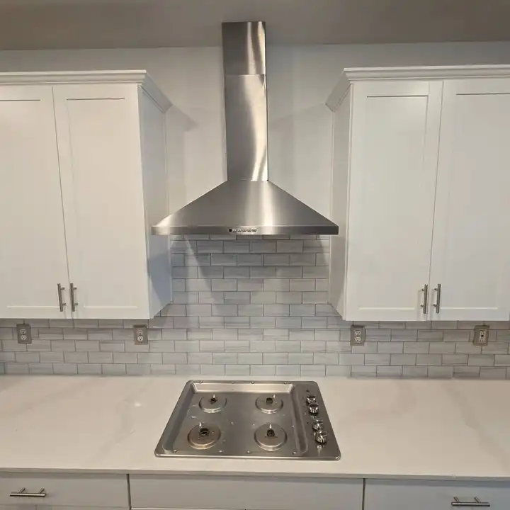 Subway tile running full height behind a stainless range hood