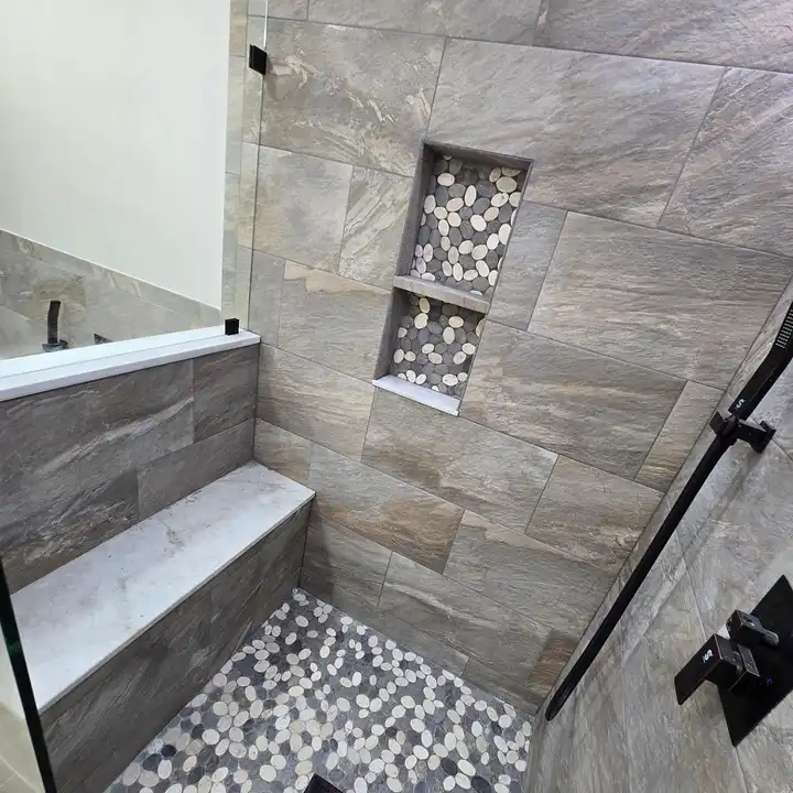 Recessed shower niche with a black metal edge trim in stone-look tile