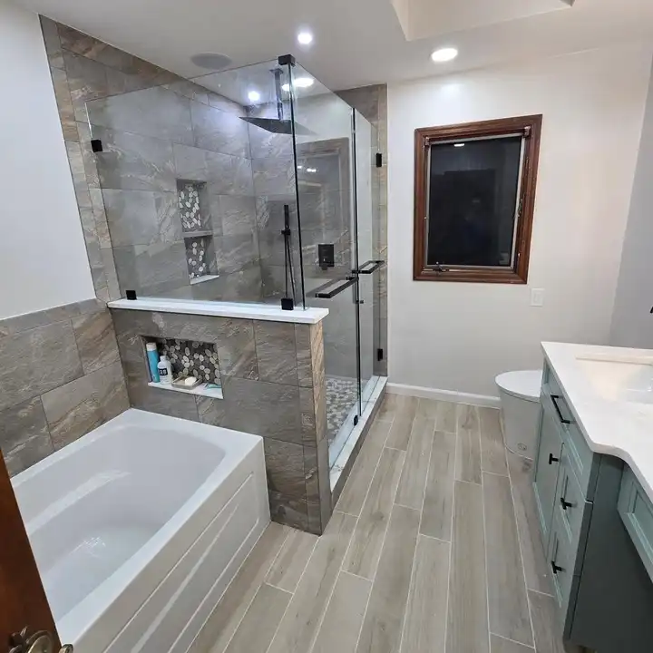 Finished bathroom with a tub, a glass shower and a wood-look plank floor