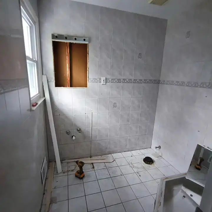 The bathroom before work: original white 4×4 tile with a blue border and a window