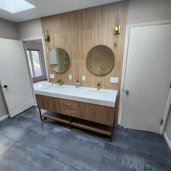 Floating double vanity with two round mirrors on a wood-look tile wall
