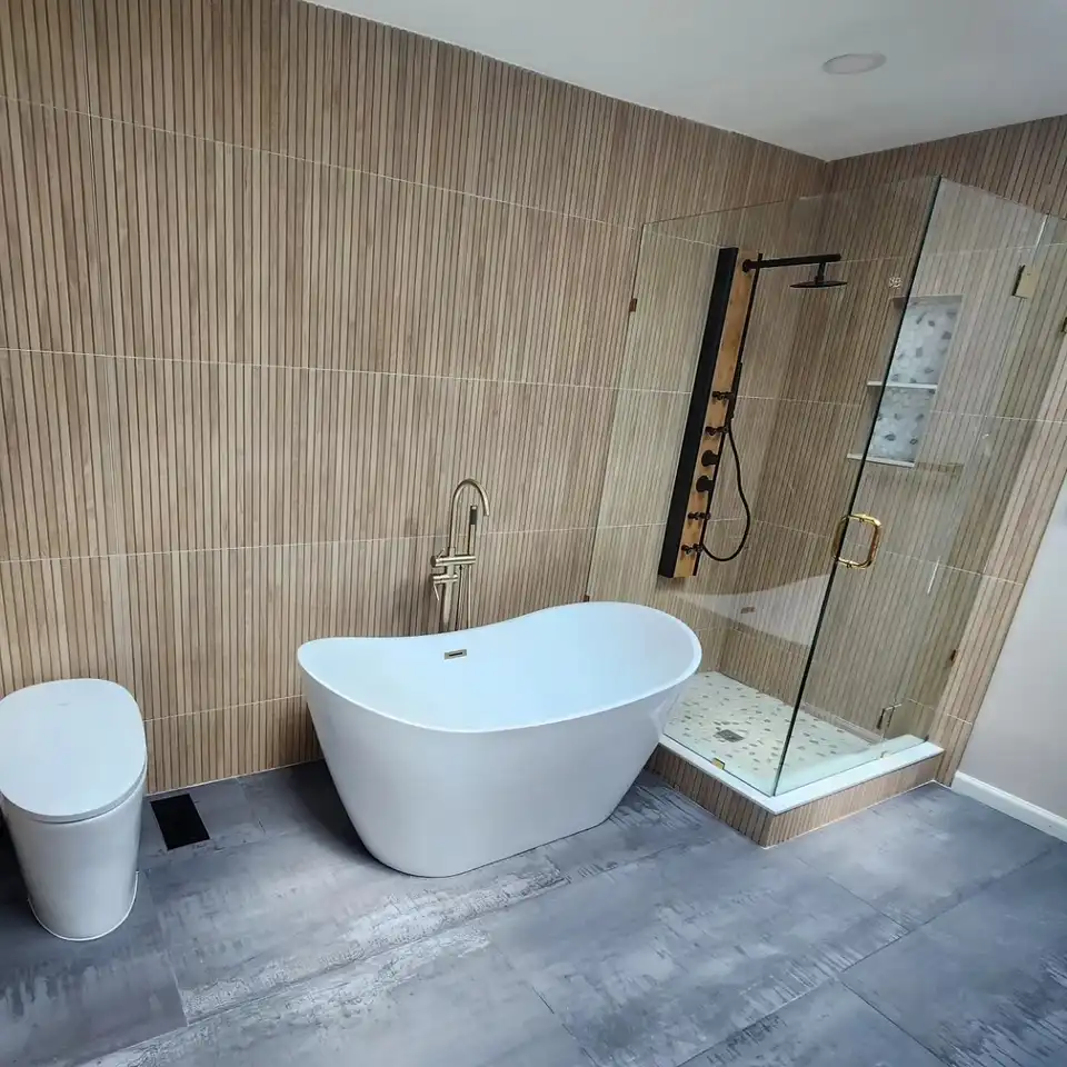 Freestanding tub against a wood-look porcelain wall beside a glass corner shower