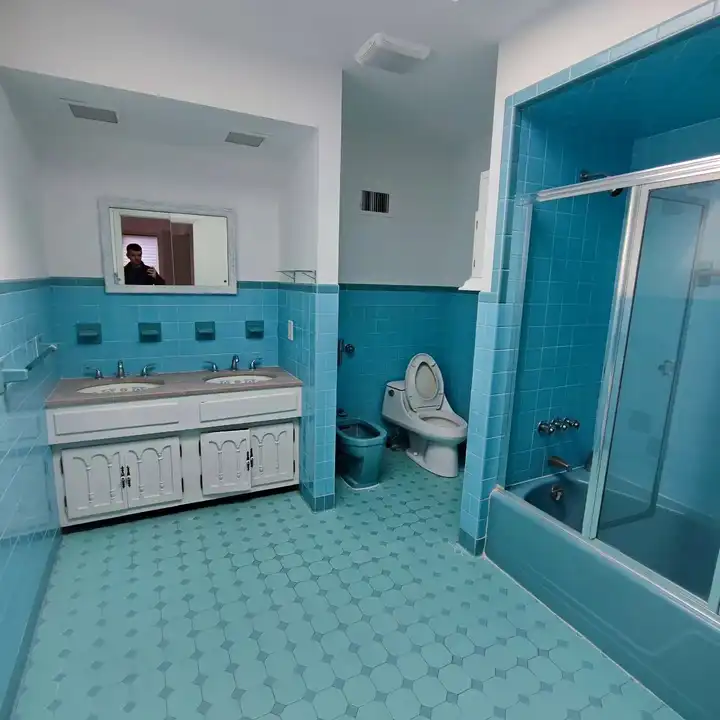 The original bathroom before work: turquoise 1960s tile around the tub