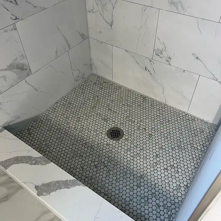 Grouted hexagon mosaic shower floor with a linear drain