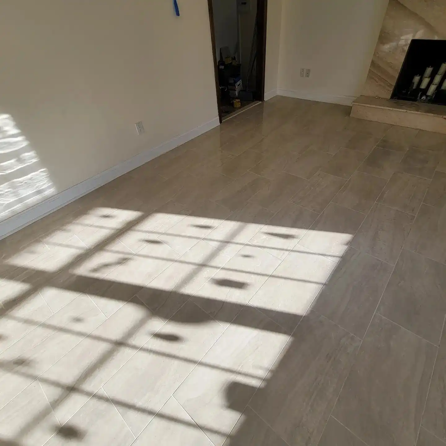 Wood-look porcelain plank floor across a living room with window light